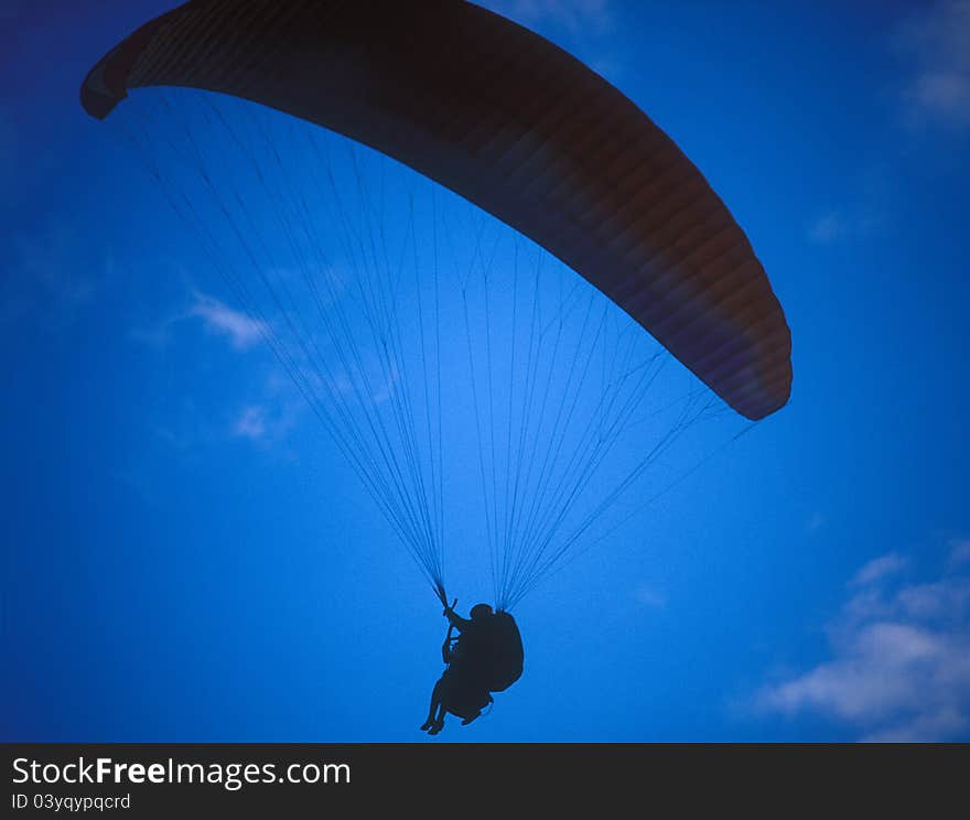 Silhouette of paraglider with two person against the blue sky. Silhouette of paraglider with two person against the blue sky.