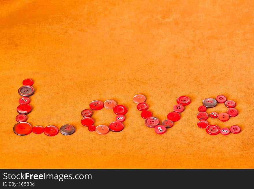 Love text written with red buttons on textured brown background. Love text written with red buttons on textured brown background