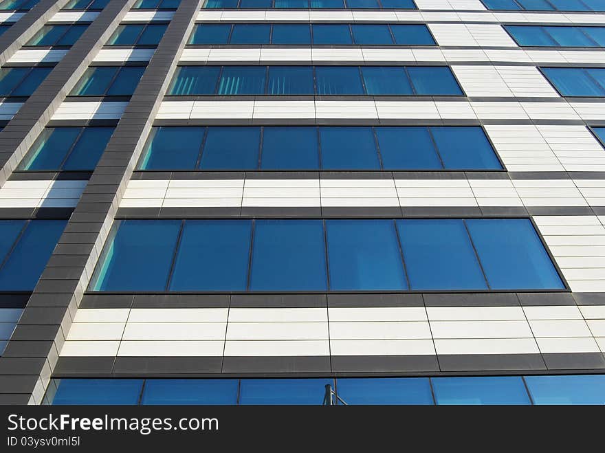 Office building wall down-up view with blue glass windows