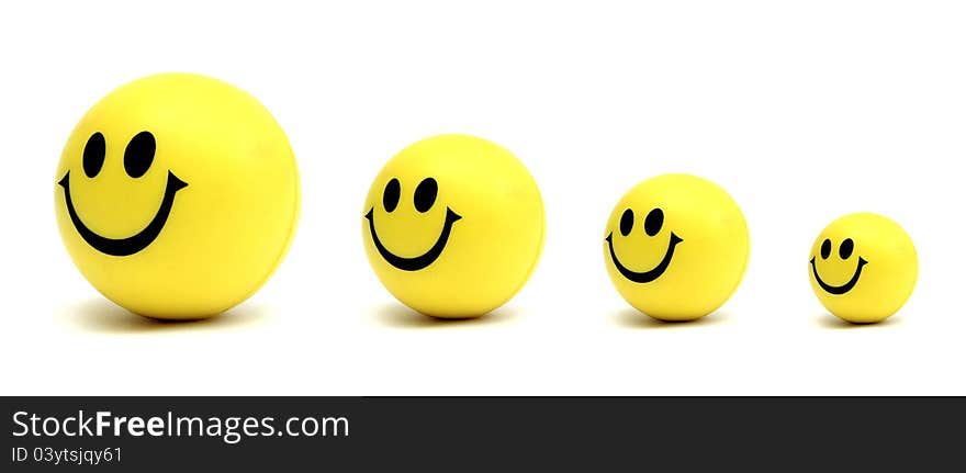 Four smiling yellow balls waiting in line over a white background