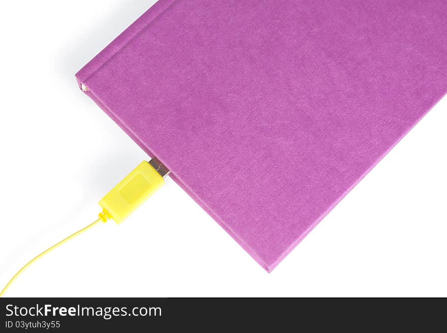 A violet-coloured closed book with a yellow cable connector leading in to the pages, isolated on white The concept idea. The paper book with USB as ebook. A violet-coloured closed book with a yellow cable connector leading in to the pages, isolated on white The concept idea. The paper book with USB as ebook.