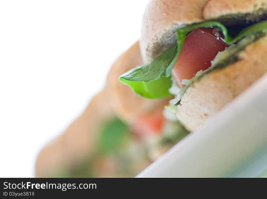 Image in macro for healthy meal containing some green grass, tomato and cheese with green olives on background ready to be served in a white plate