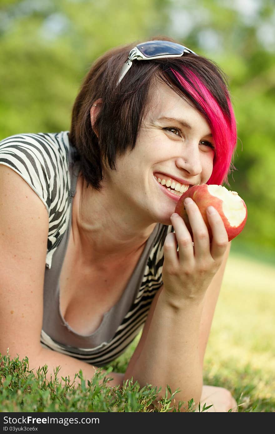 Young punk woman eating an apple