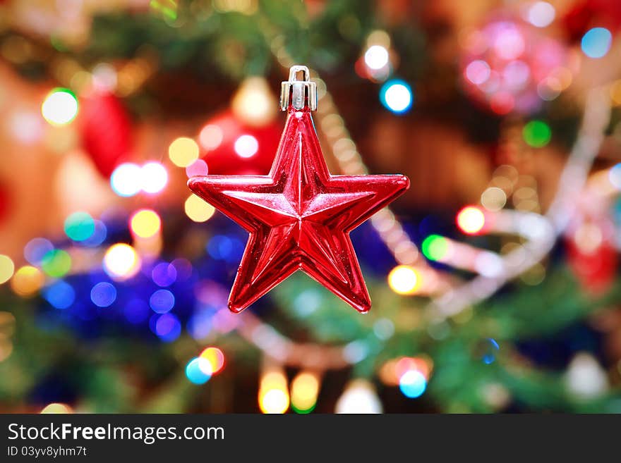 Red christmas star with decorated tree on background. Red christmas star with decorated tree on background