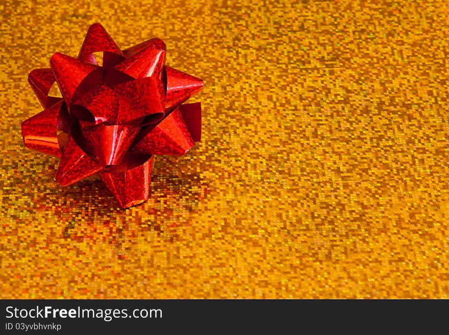 Shiny red bow on a shiny gold background. Shiny red bow on a shiny gold background.