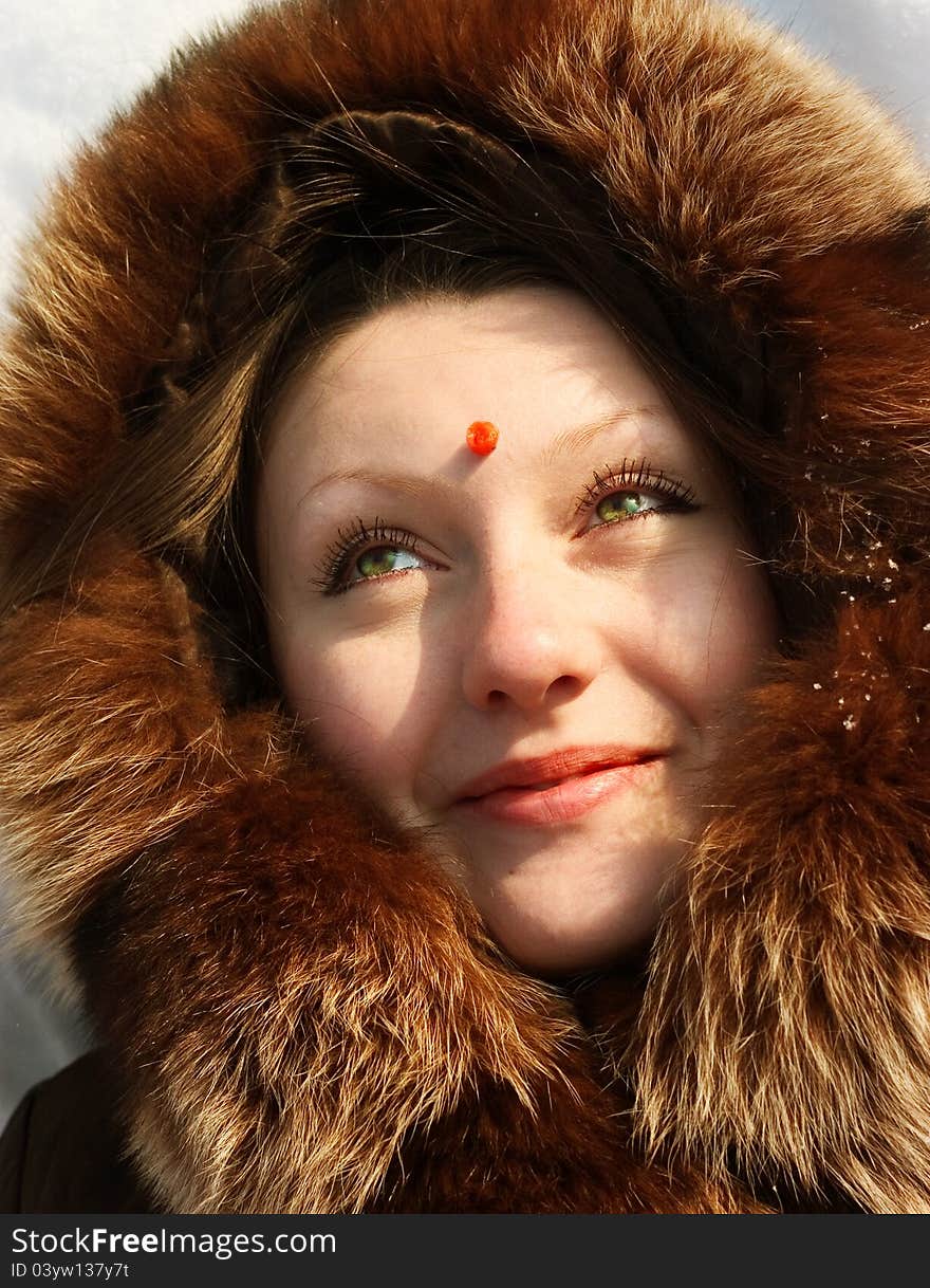 Girl lying in snow with berry of mountain ash on  forehead. Girl lying in snow with berry of mountain ash on  forehead