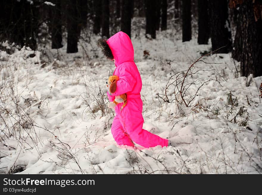 A kid with pink snow suit walking on snow. A kid with pink snow suit walking on snow