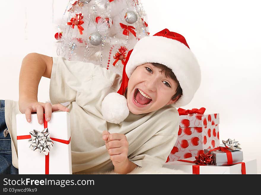 Cheerful child with Christmas gifts and a Christmas tree on a white background