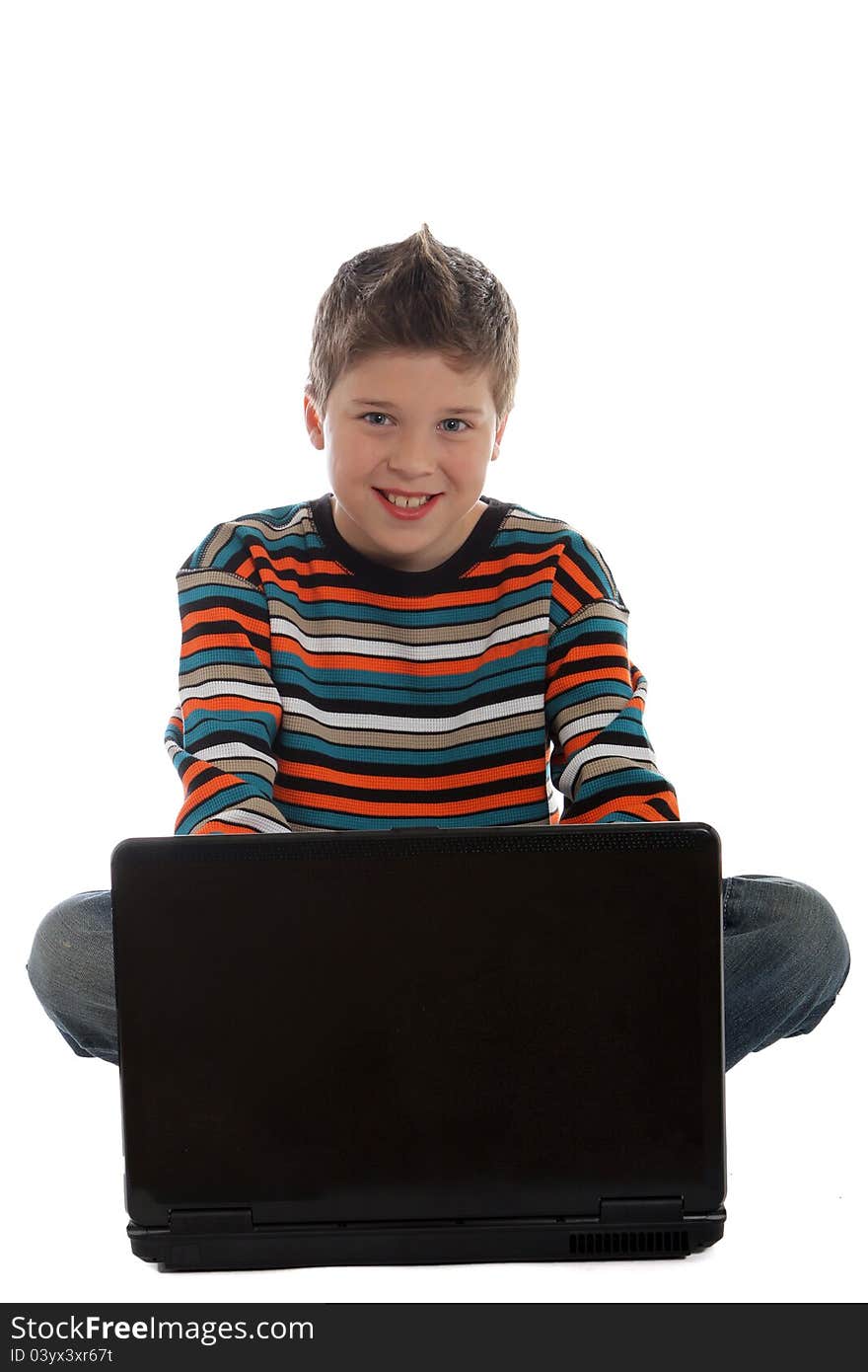 Boy sitting using a laptop computer. Boy sitting using a laptop computer