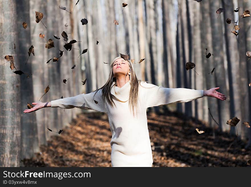 Beautiful blonde girl with falling leaves in the autumn park. Beautiful blonde girl with falling leaves in the autumn park