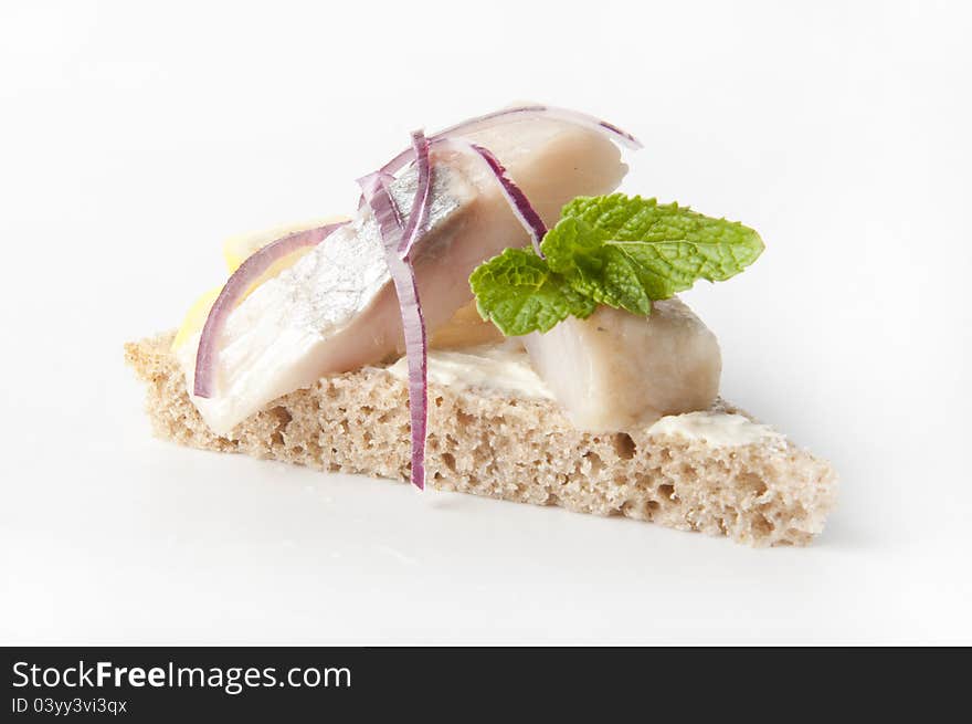 Sandwiches of rye bread with herring, onions and herbs.