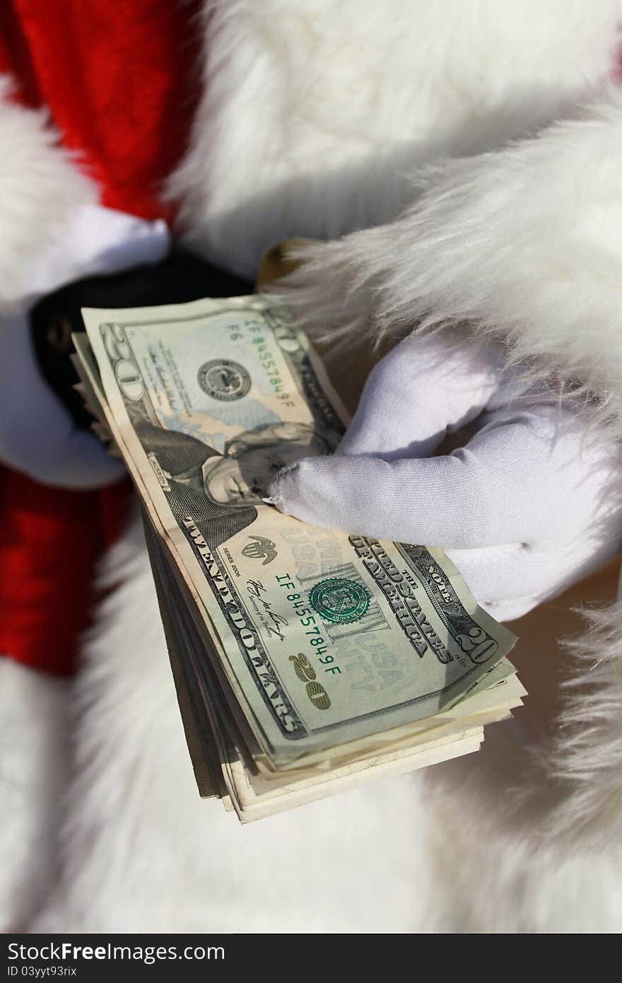 Santa Claus holding a stack of cash in his gloved hand. Santa Claus holding a stack of cash in his gloved hand.