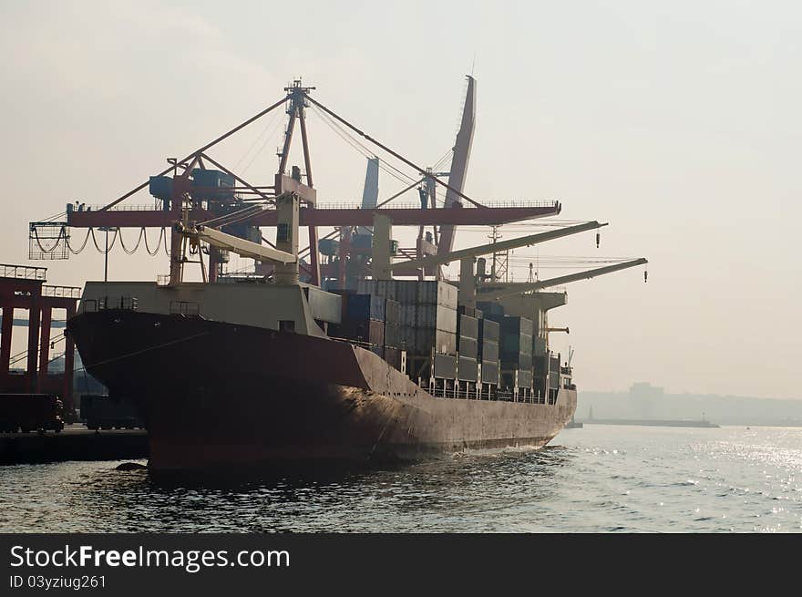 Huge container ship with large lifts / cranes. It is loaded with containers.