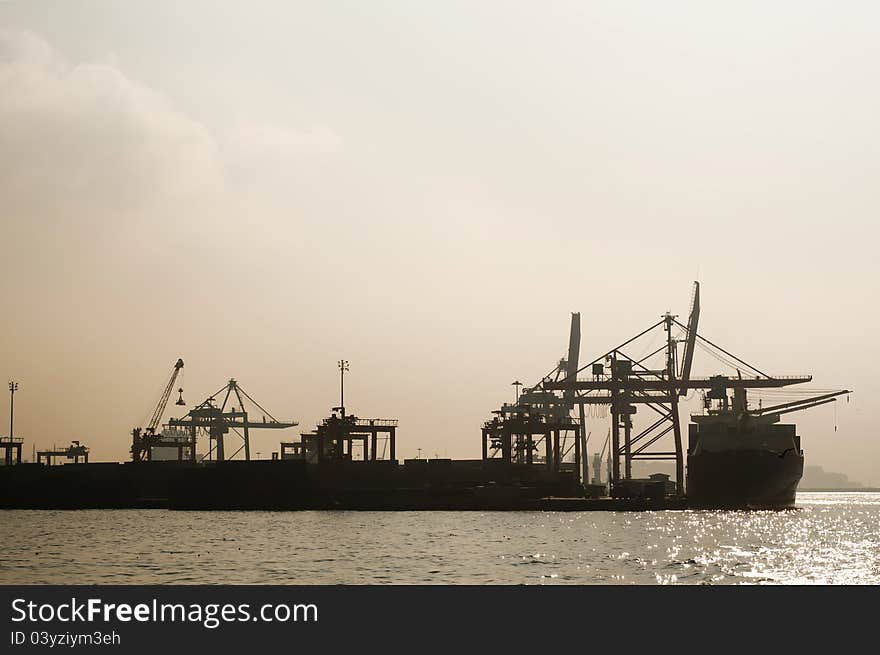 Silhouette of a huge container ship and some cranes on the sea. Silhouette of a huge container ship and some cranes on the sea.