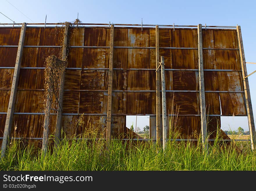 Huge rusty billboard in grass field