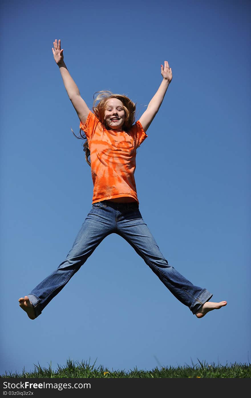 Young Girl Jumping against a blue sky. Young Girl Jumping against a blue sky