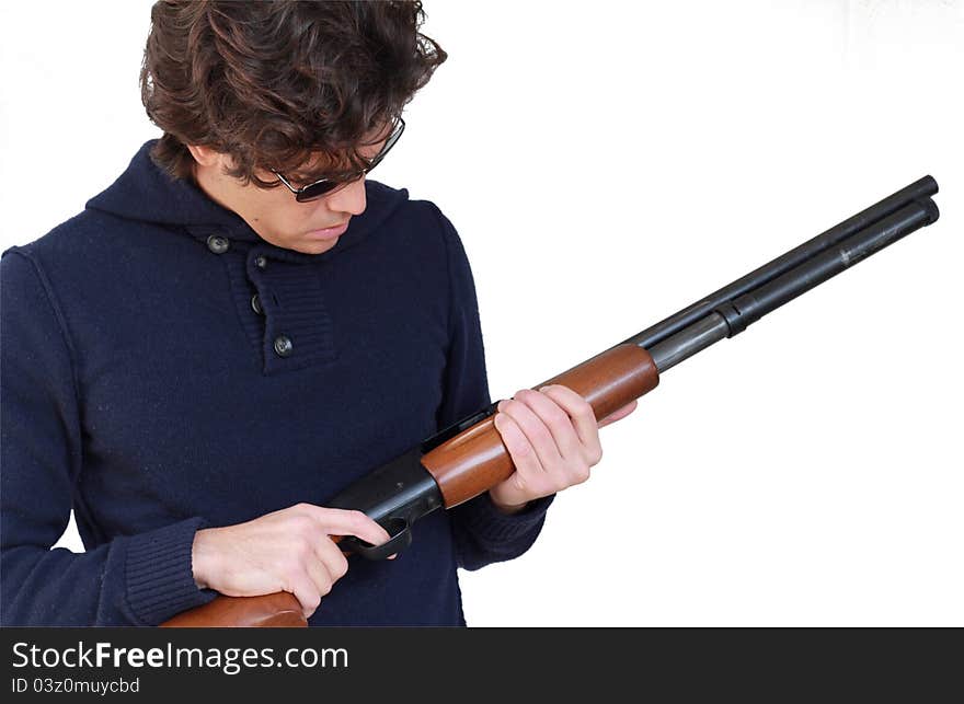 Young man with a shotgun is checking for bullets isolated