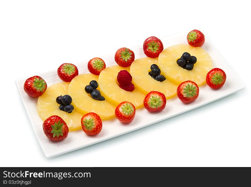 Pineapple slices with berries on white background