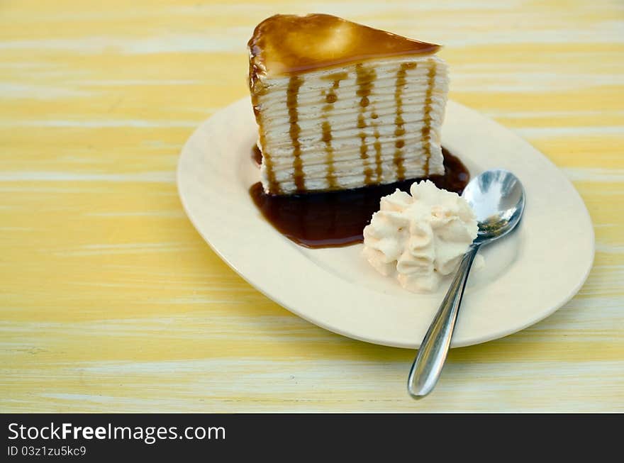 Side of Cream cake topped with caramel