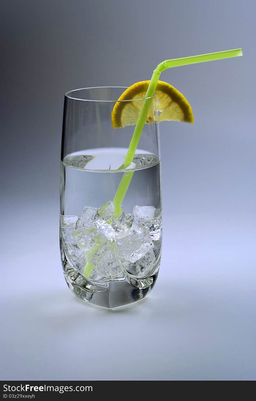 Glass of cold water with ice cubes and lemon slice. Glass of cold water with ice cubes and lemon slice