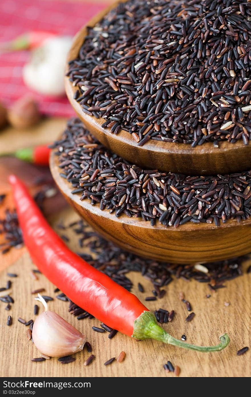 Brown rice in wooden bowls and red chili. Brown rice in wooden bowls and red chili