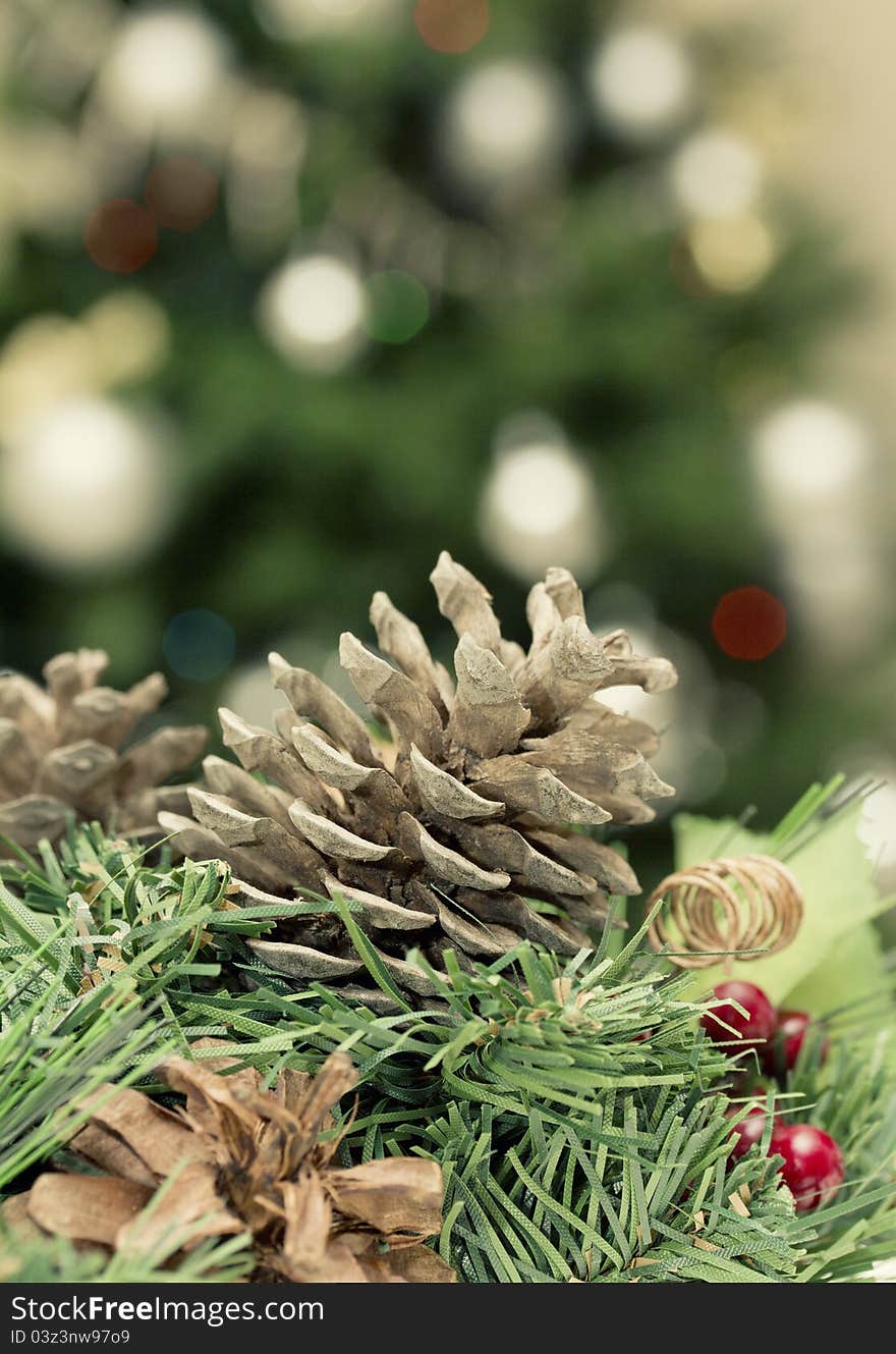 Christmas decoration: fir sprig,cones and blurry light from Christmas tree