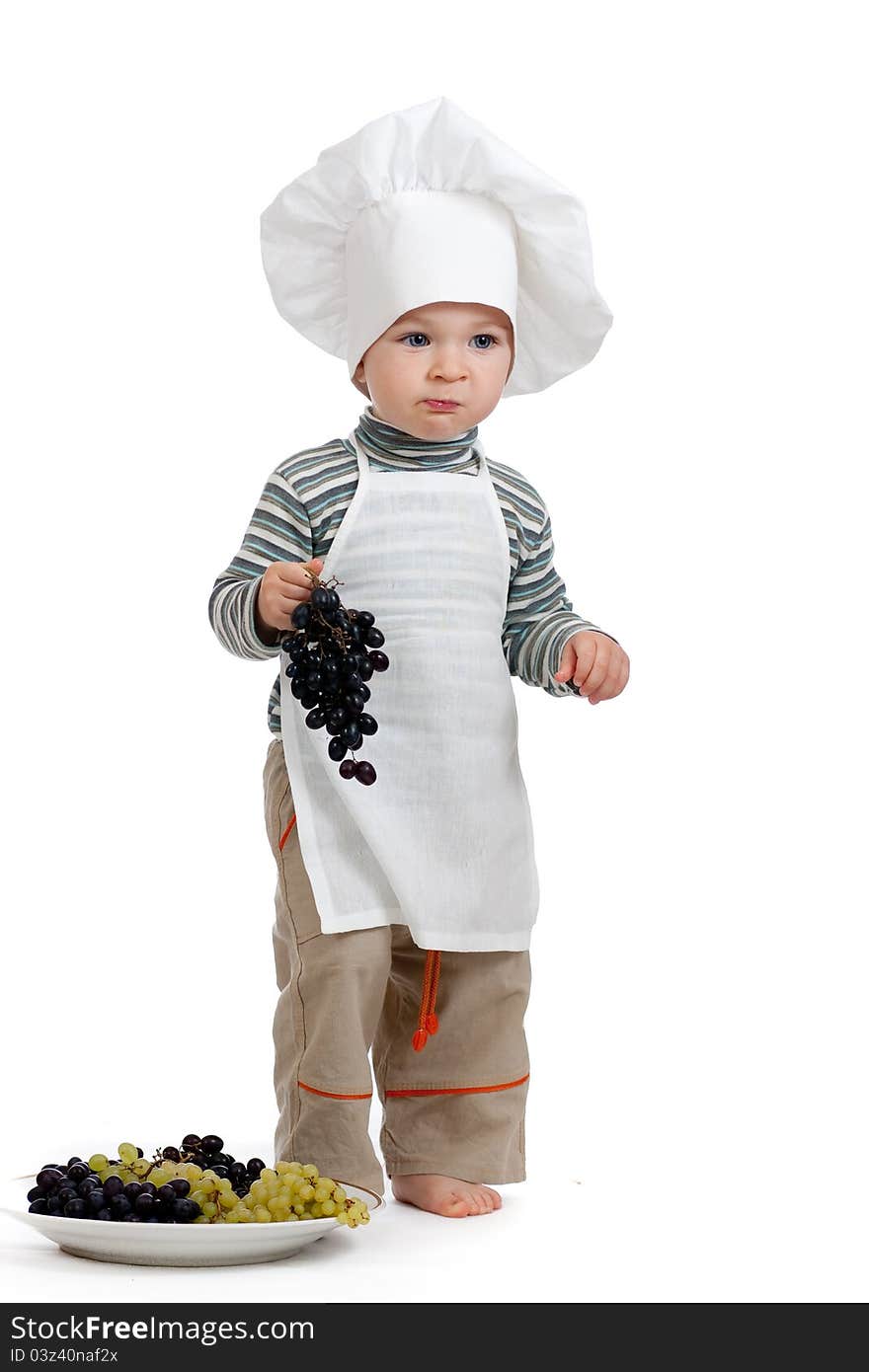 Child as chef with green and black grape over white background. Child as chef with green and black grape over white background