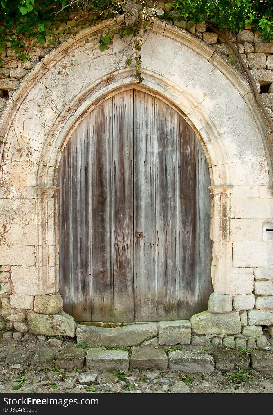 Old closed wooden door with concrete arc with brick wall