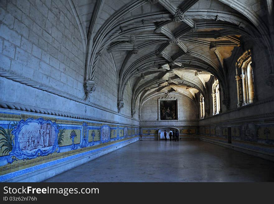 This massive stone refectory is in the monastery of jeronimos in lisbon portugal. the building is acclaimed for its vaulted roof and mouldings