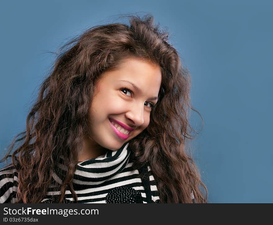 Portrait of beautiful smiling girl isolated on blue background