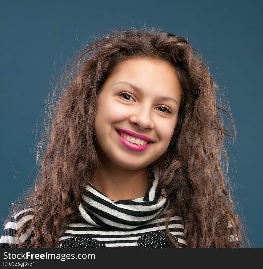 Portrait of beautiful smiling girl isolated on blue background