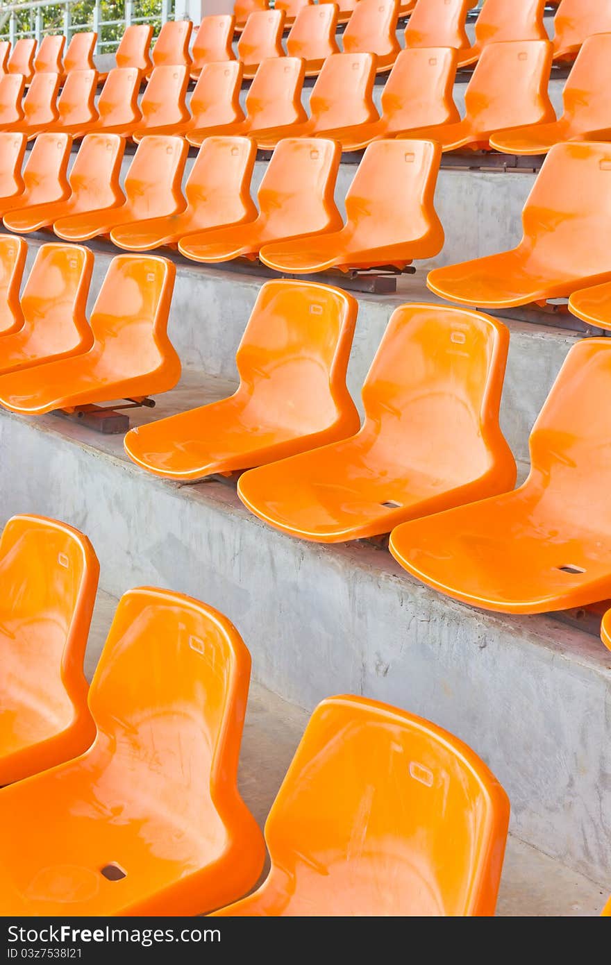 Sheer orange seats arranged in a row. Sheer orange seats arranged in a row.