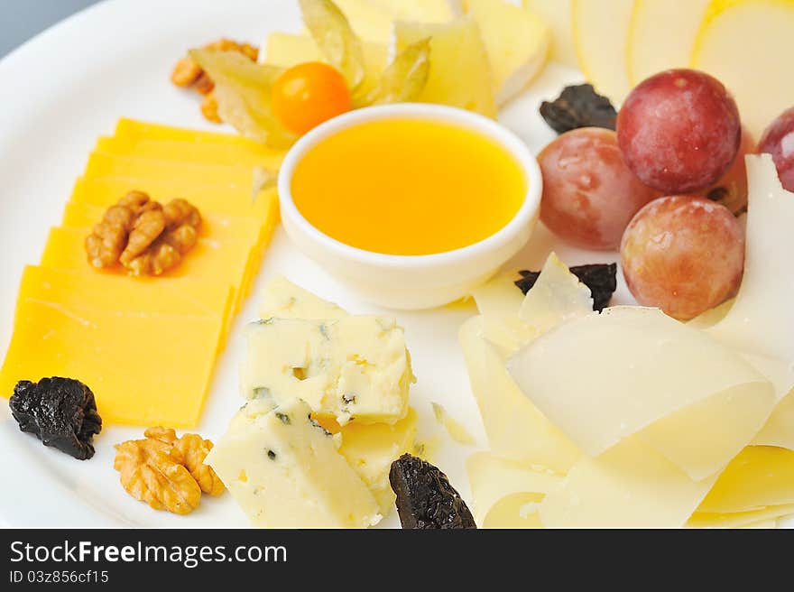 Bites of different cheeses with honey  and nuts. Bites of different cheeses with honey  and nuts