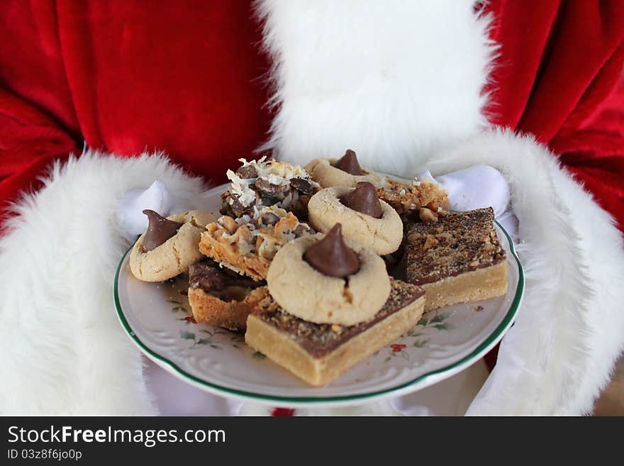 Santa's gloved hands holding a plate of Christmas cookies. Santa's gloved hands holding a plate of Christmas cookies.