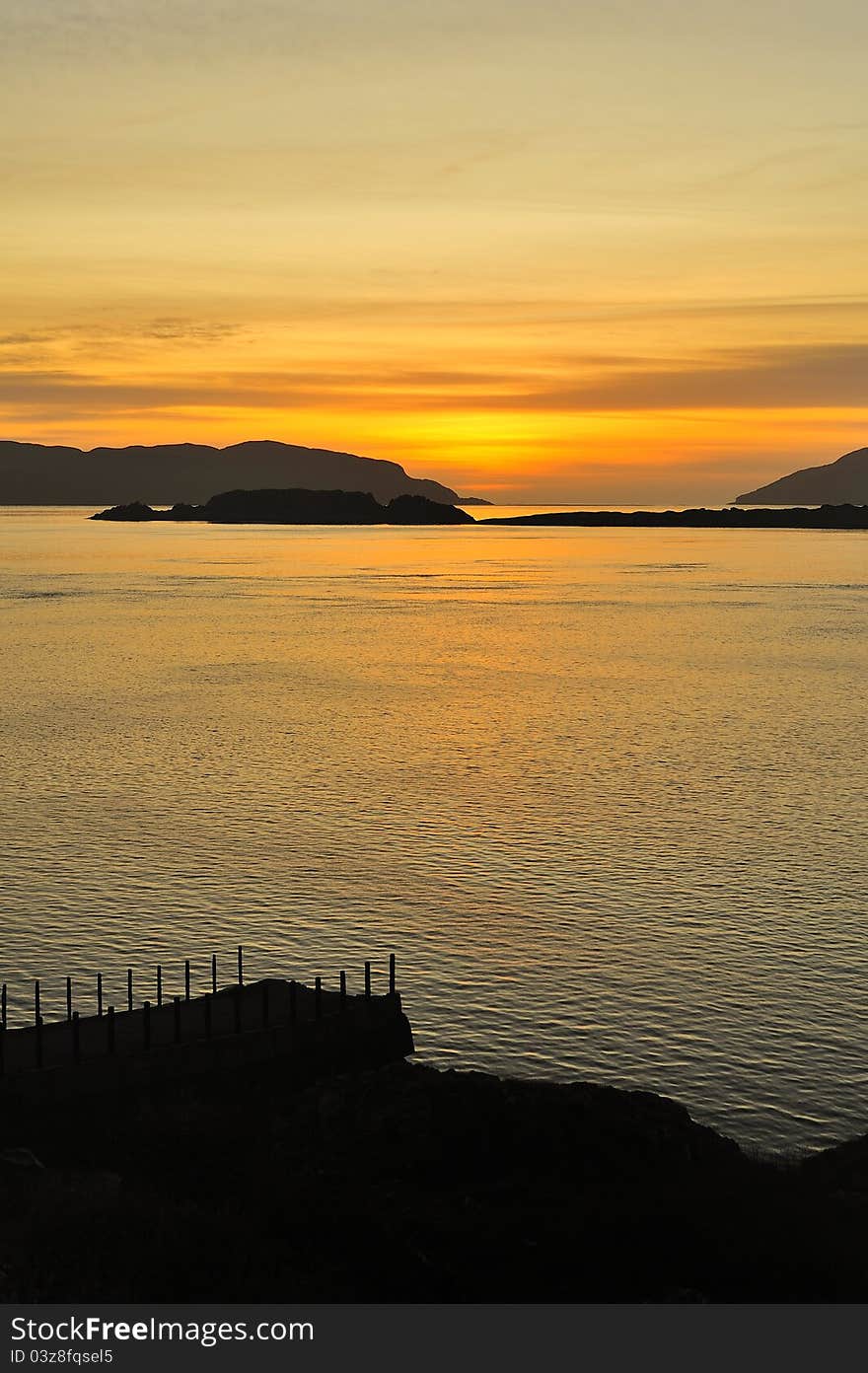 A romantic sunset shot showing the Corryvreckan narrows in the distance, over the sound of Jura, between the islands of Scarba and Jura. These narrows contain one of the largest tidal whirlpools in the world. The shot was taken from the old steamer pier at Aird in Argyll, Scotland. A romantic sunset shot showing the Corryvreckan narrows in the distance, over the sound of Jura, between the islands of Scarba and Jura. These narrows contain one of the largest tidal whirlpools in the world. The shot was taken from the old steamer pier at Aird in Argyll, Scotland.