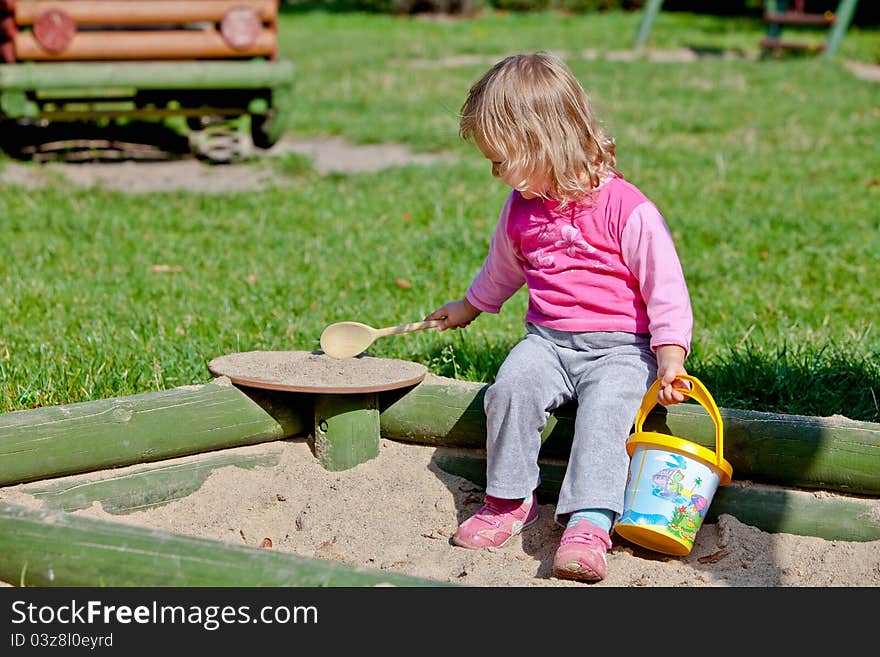 Cute toddler girl playing with sand toy on a sandbox. Cute toddler girl playing with sand toy on a sandbox