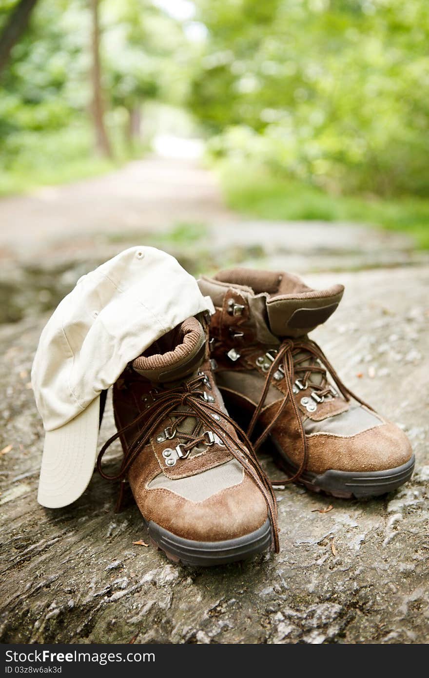 Hiking Boots And Hat In The Woods