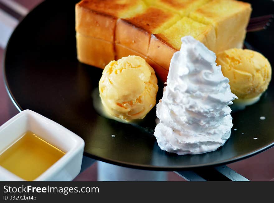 Toast and whipping cream with vanilla ice cream served with honey sauce. Toast and whipping cream with vanilla ice cream served with honey sauce