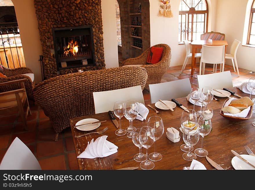 Interior of a restaurant with set wooden table and a fireplace. Interior of a restaurant with set wooden table and a fireplace