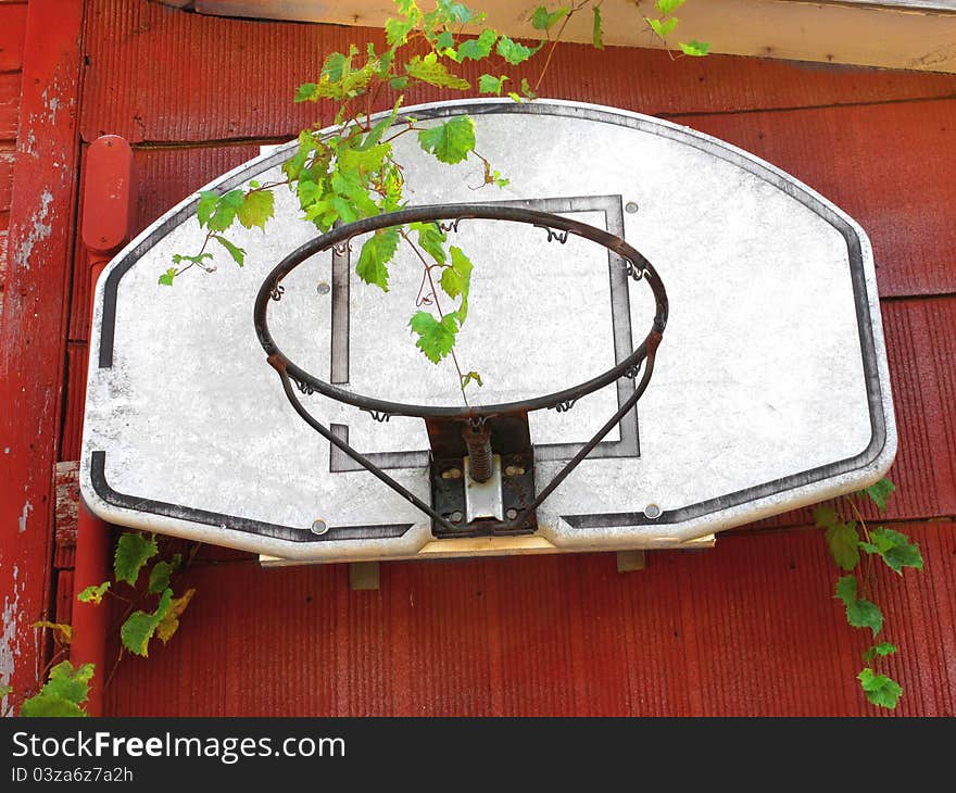 Old and unused basketball hoop with no net, attached to the side of an old red building. Old and unused basketball hoop with no net, attached to the side of an old red building.