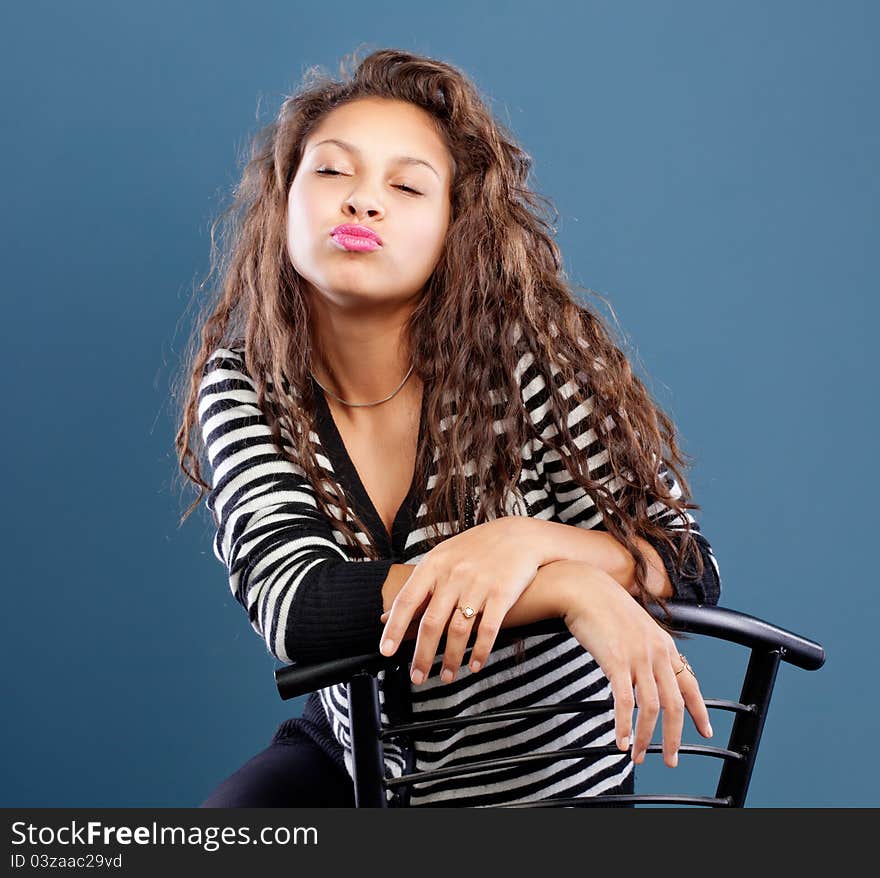 Young happy girl sitting with closed eyes and lips ready to kiss