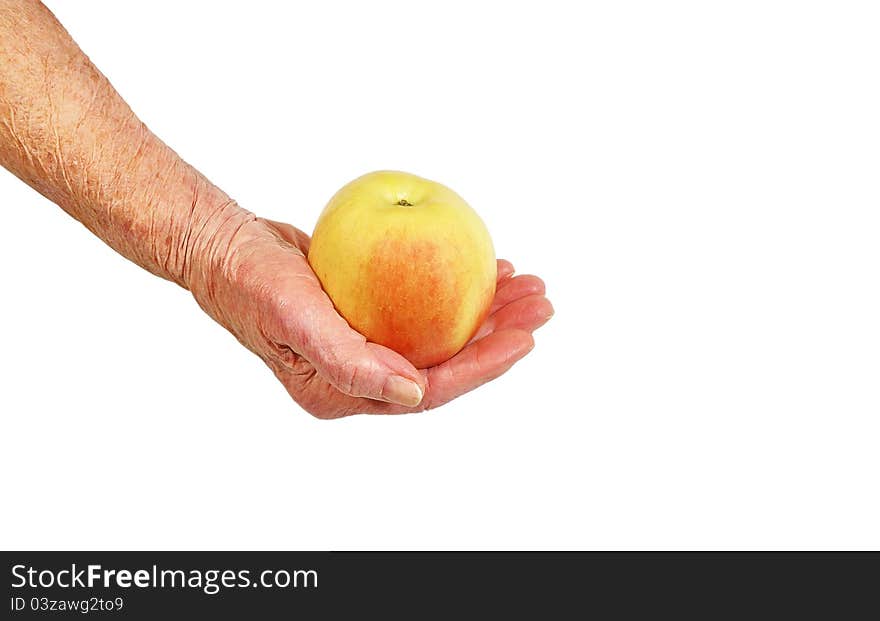 An elderly woman's hand with an apple on a white background. An elderly woman's hand with an apple on a white background