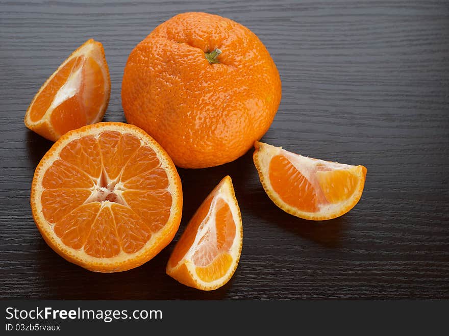 Tangerines on the background of dark wood