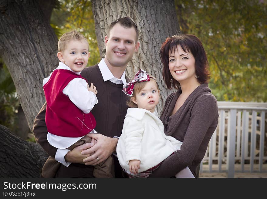 Young Attractive Parents and Children Portrait Outside in the Park. Young Attractive Parents and Children Portrait Outside in the Park.