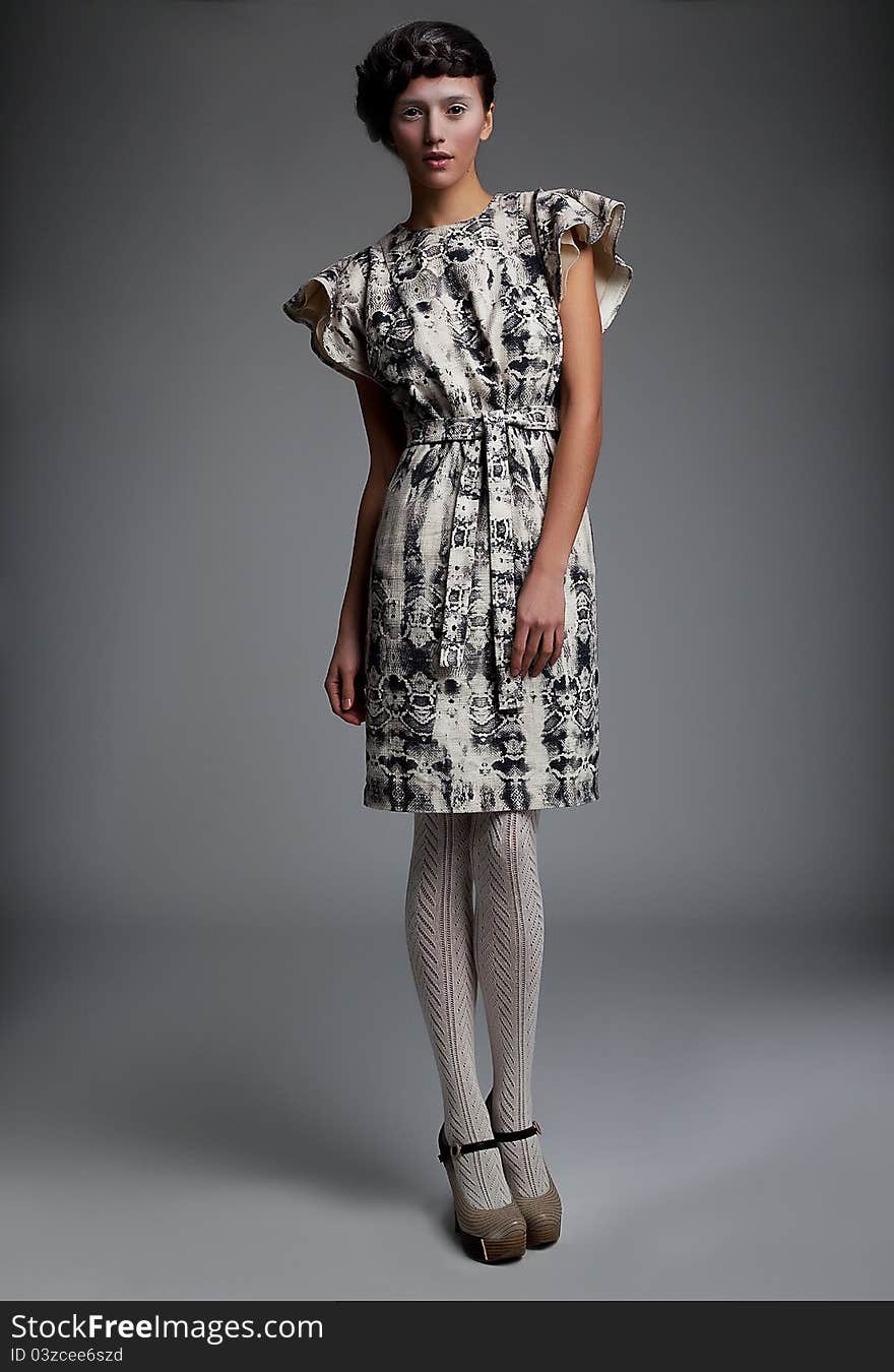 Fashion model in retro dress standing in studio