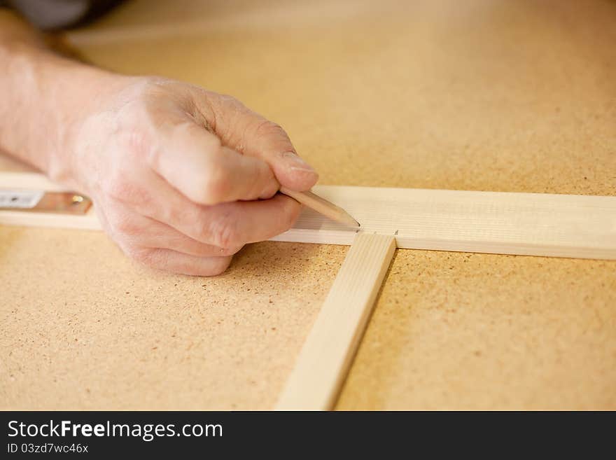 Marking wood with a black pencil on  a workbench