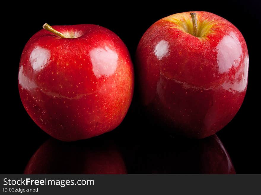 Two red glossy apples on black background. Two red glossy apples on black background