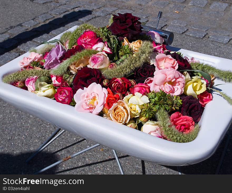 Street decoration roses and flowers arranged in an old white sink. Street decoration roses and flowers arranged in an old white sink