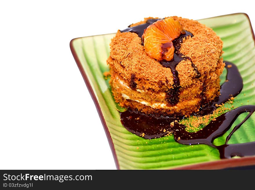 Close-up on a slice of honey cake with chocolate on white background