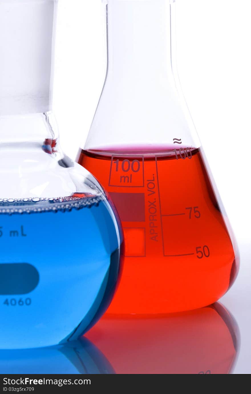 One blue and one red laboratory flask used in scientific research. One blue and one red laboratory flask used in scientific research